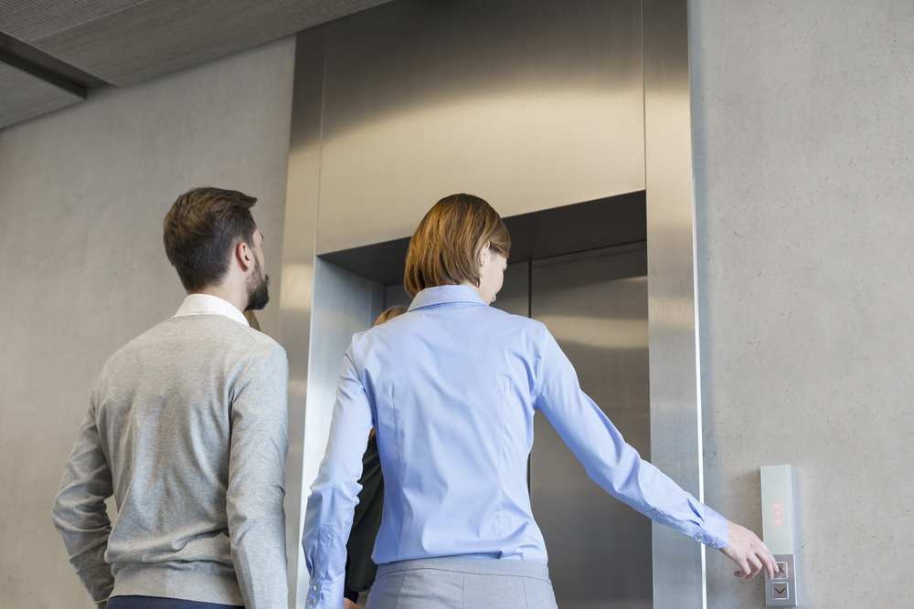 Business colleagues waiting for elevator at corporate office